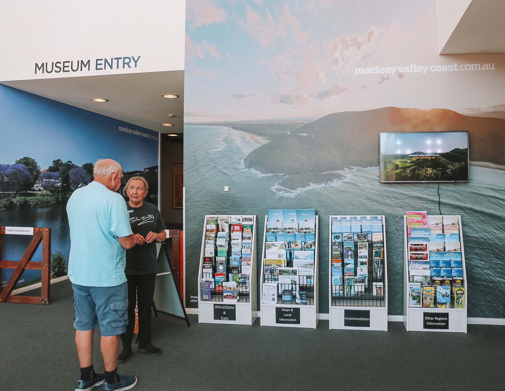 Customer experience officer helping with visitor information at the Slim Dusty Centre.